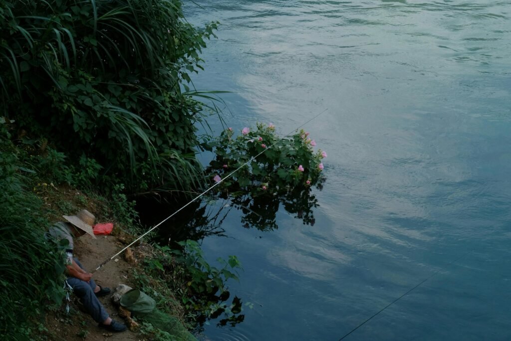 peaceful scene of a man fishing in a lake after realising their burnout symptoms and taking the time to relax and meditate
