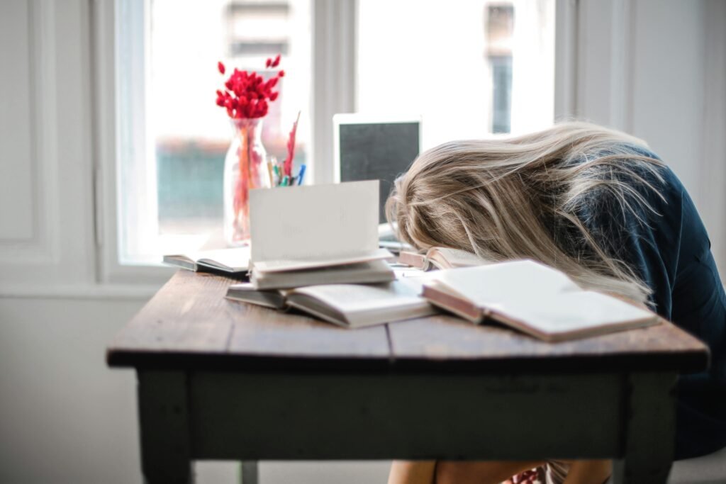 young professional looking exhausted at their desk, showing burnout symptoms